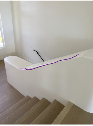 Metal Handrail installed on a modern staircase with a smooth wall design, enhancing safety and style.