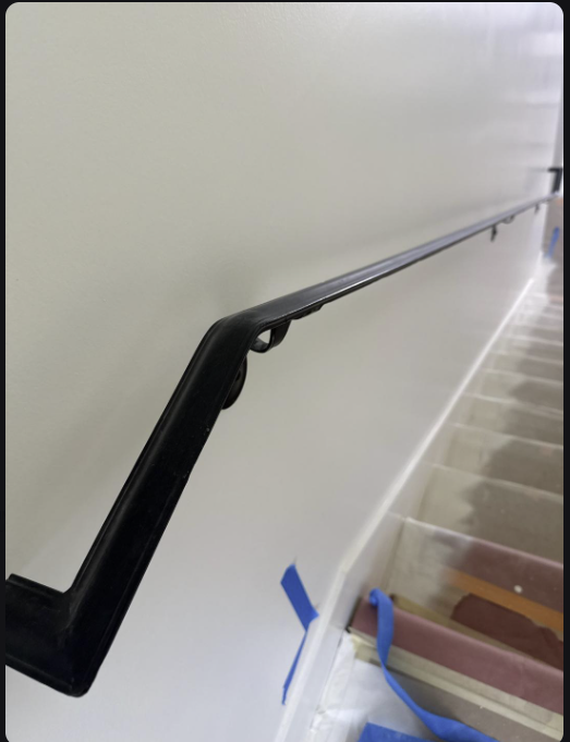 Metal Handrail 1.75 Inch cap rail with wall return installed along a clean staircase for safety and style.