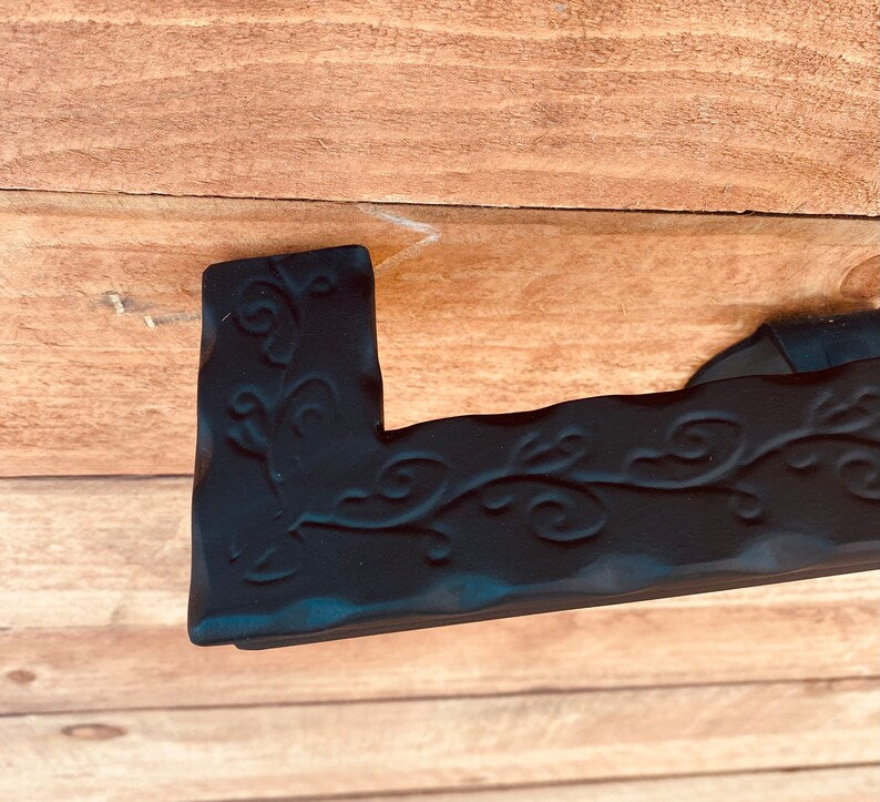 Metal Handrail close-up showcasing hammered and engraved flat black design on wood background.