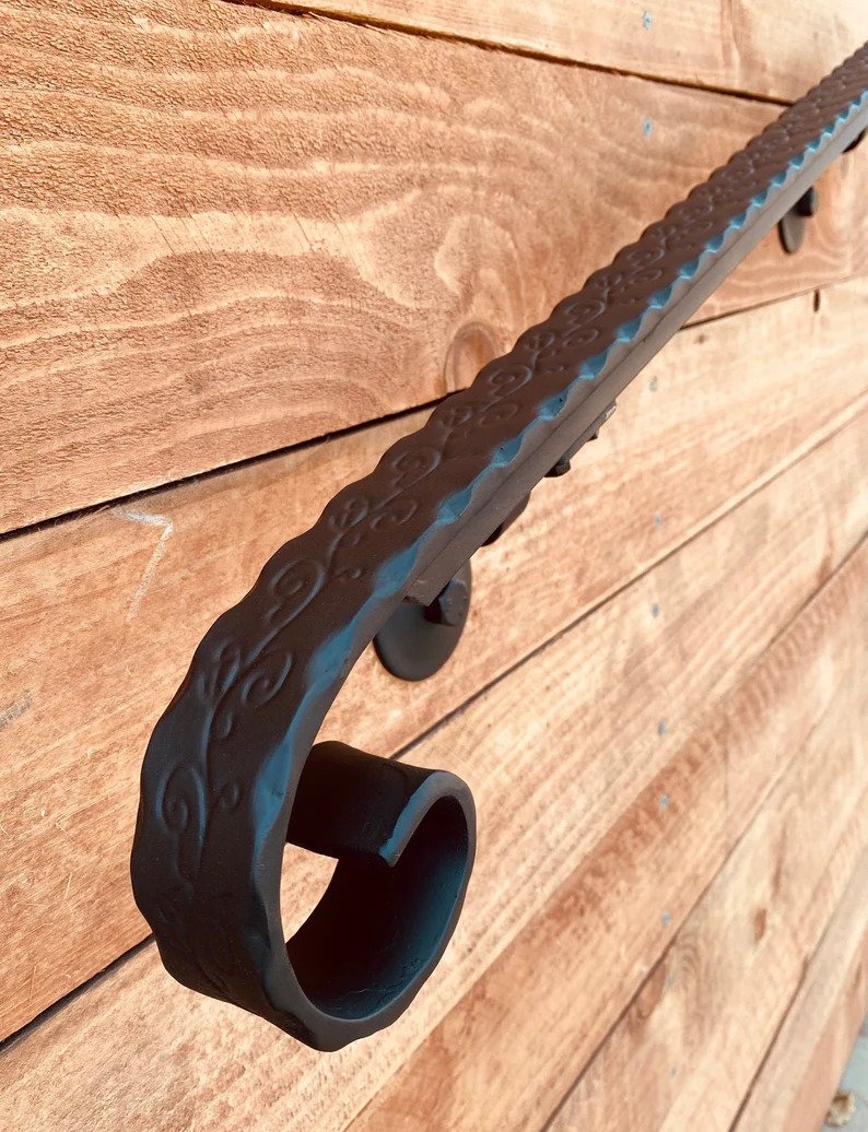 Handrail Installation service showcasing a close-up view of an elegantly designed handrail on a wooden surface.
